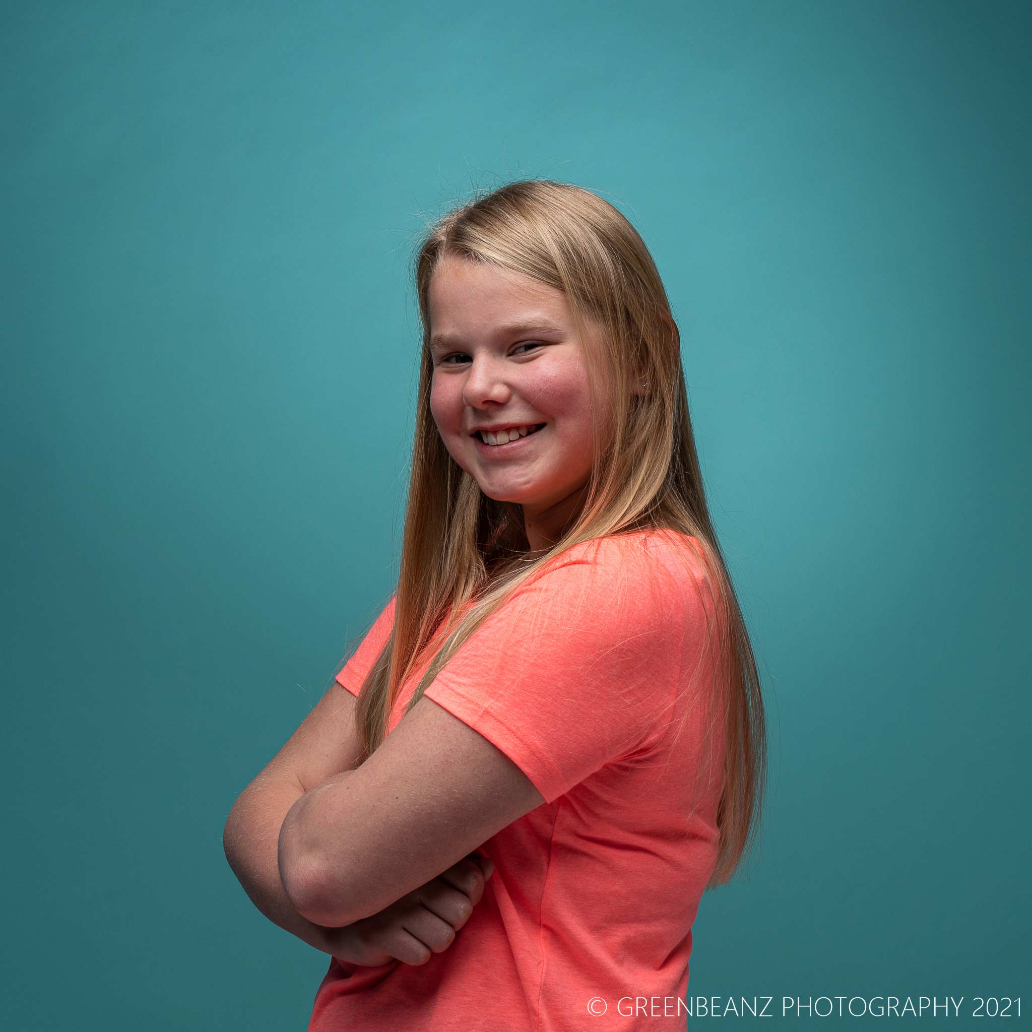 Young Fair headed Plymouth actress Daisy posing for photographic portfolio against Teal backdrop